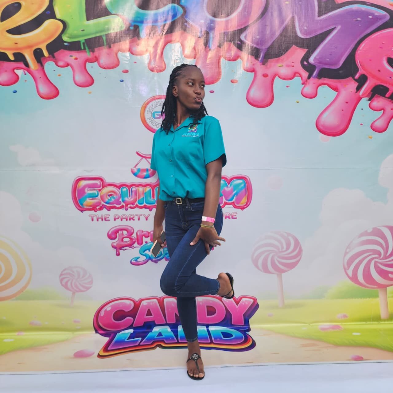 Team member posing at a Candy Land party backdrop